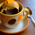 En kaffekop med orange-chokolade mug cake og is på toppen.